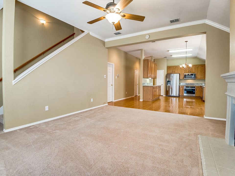 Open floor plan with view from living room looking toward eat-in kitchen and stairs to game room featuring a gas fireplace