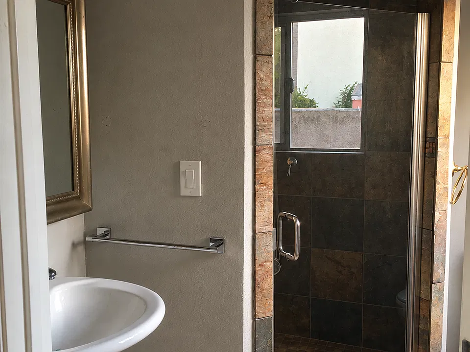 Bathroom with antique medicine cabinet and stone shower stall.