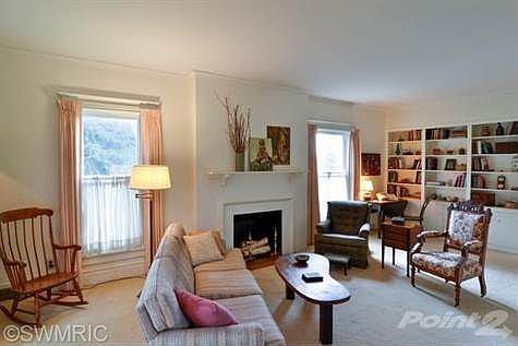 Large living room with decorative fireplace and custom built-in bookcase.
