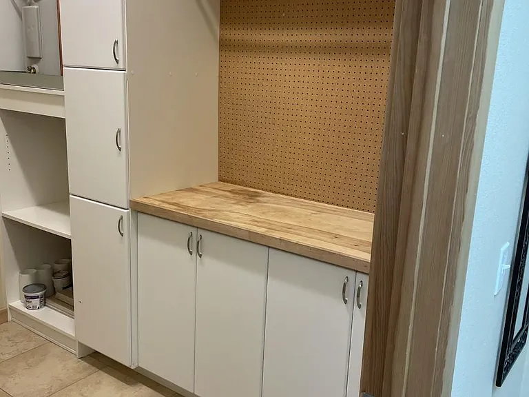 Another view into laundry/storege/work room, lots of cabinets for storage