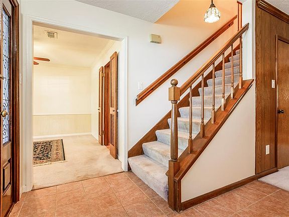 To the Left is the Formal Dining Room and the stairs to the upper story, in front. Notice the Tiffany Light over the entryway.