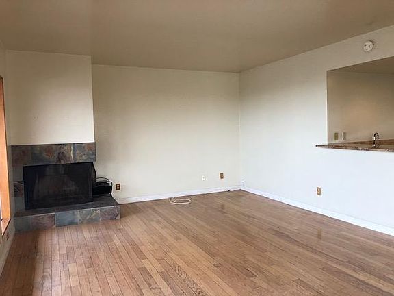 Wood burning fireplace in living room and wet bar opening.