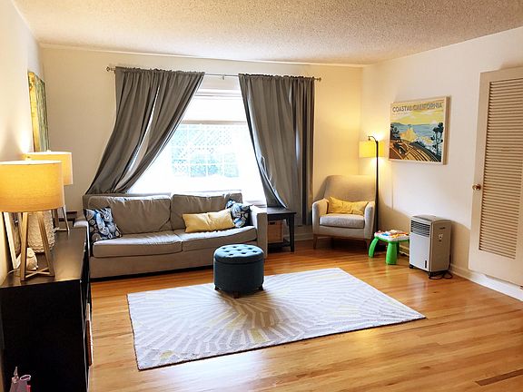 Large living room with bay window view to backyard