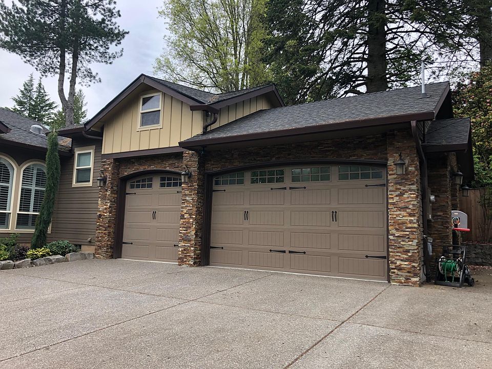 Three car garage with RV or boat parking to the right of the garage.