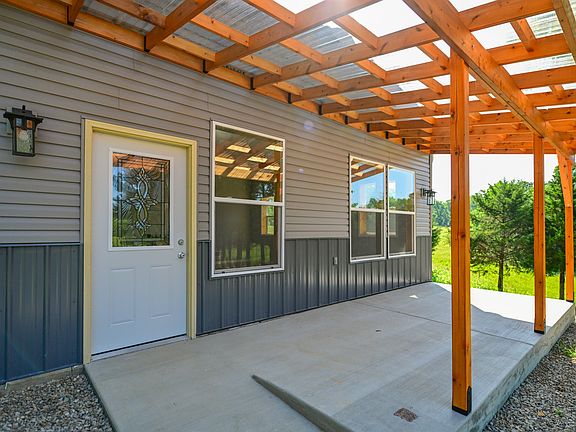 A slight ramp for ease of access. There are two outlets on the porch. The roofing is polycarb.