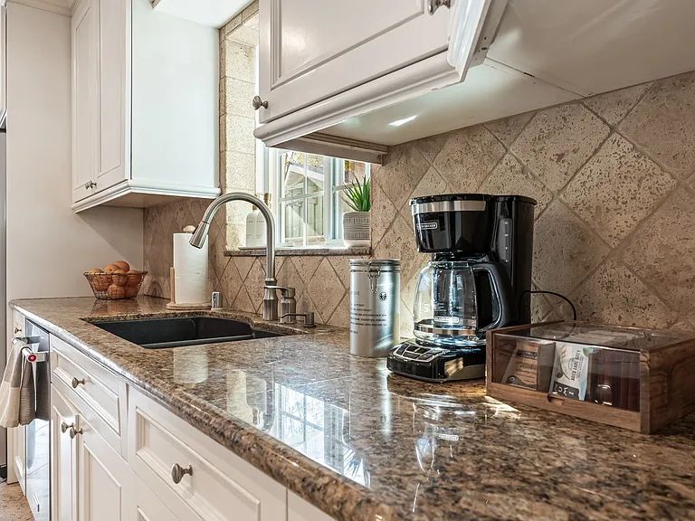 Fully stocked kitchen with abundant natural light, backyard views, bar seating, and a convenient work station for everyday living.