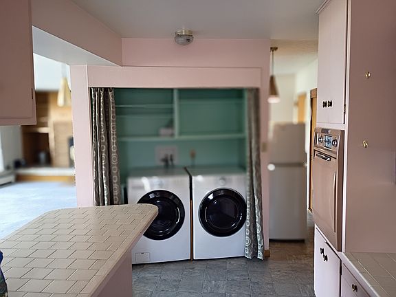 Another kitchen view showing laundry service and extra fridge. (You can one end of the giant living room, dinning room to the left on this photo)