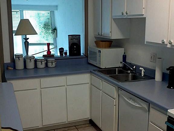 Great galley kitchen with all electric appliances that stay with the home. Laminate countertops, lot