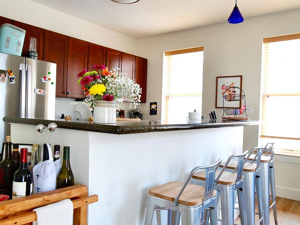 Four-stool counter island with kitchen in background.