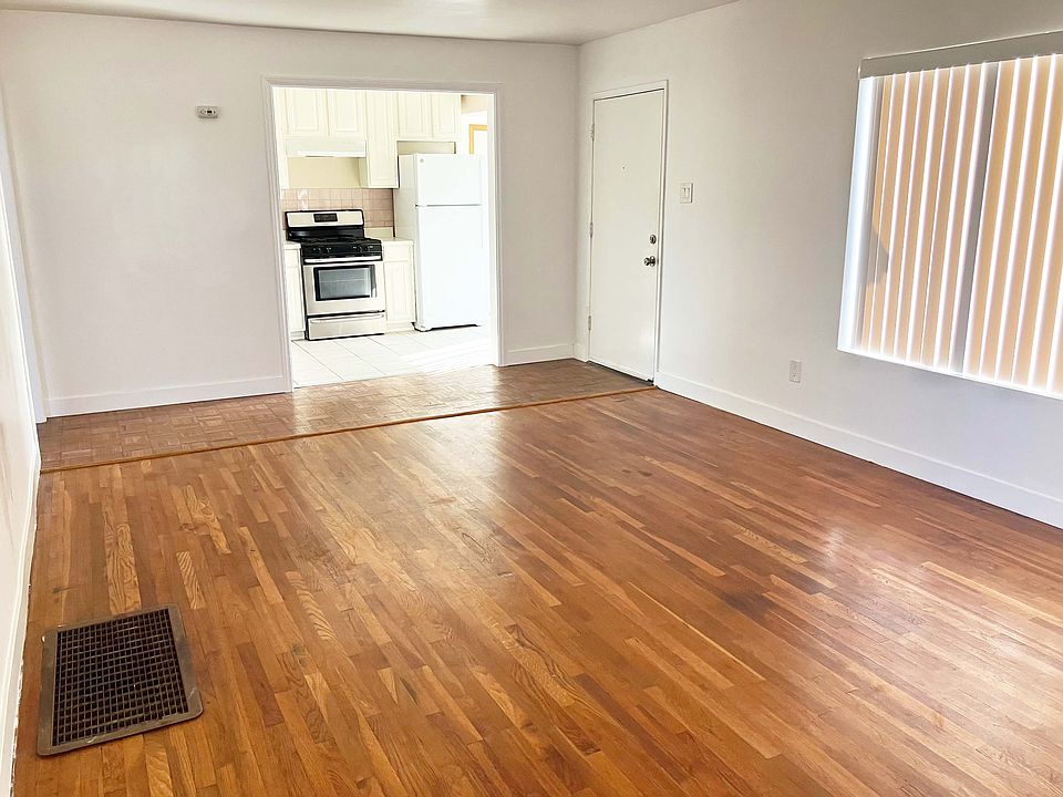 View of kitchen from far corner of living room, featured door is main entrance to house.