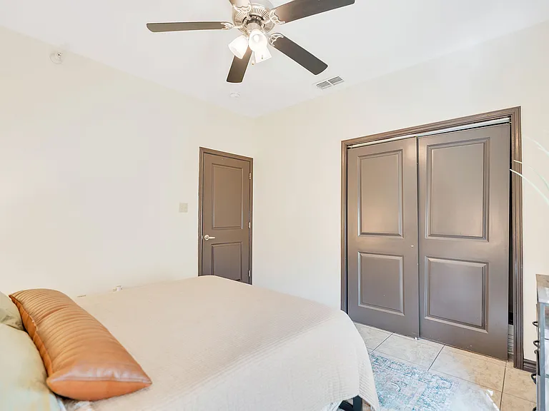 Bedroom at La Joya Apartments in Laredo, Texas, with a ceiling fan above a neatly made bed