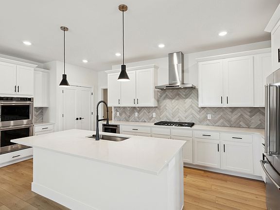 The kitchen has beautiful white wood cabinets with black hardware.