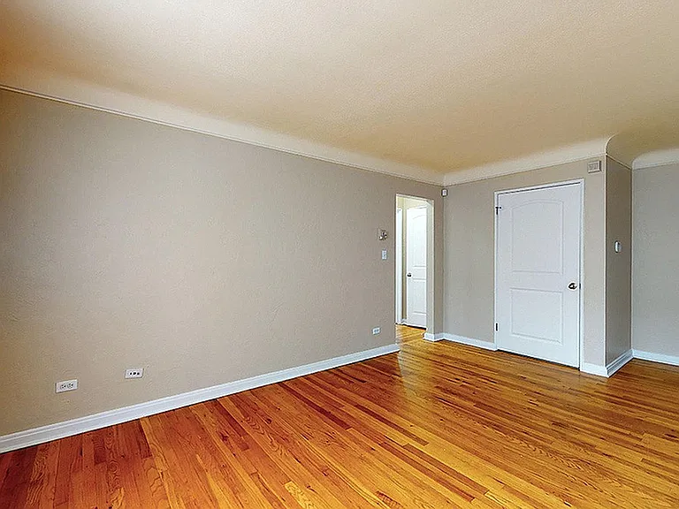 Bright and open living space with gleaming hardwood floors and neutral walls, perfect for personalization.