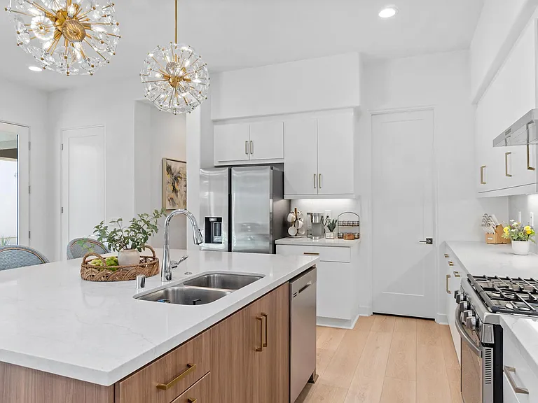 This kitchen features an abundance of lighting and bar-height dining seating for three.