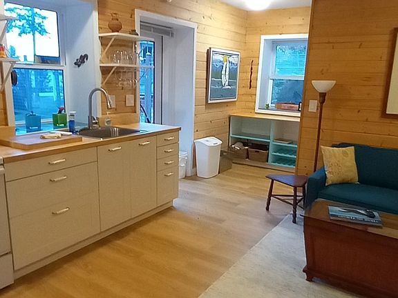 Full length of great room with door to outside and storage at far end