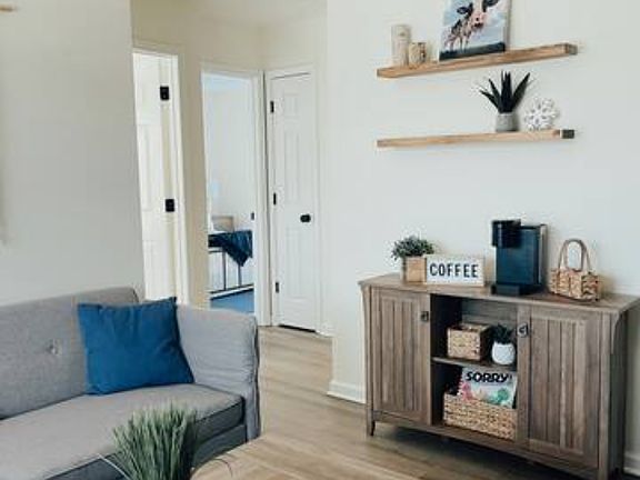 Living room looking toward coffee station and two bedrooms and bathroom.