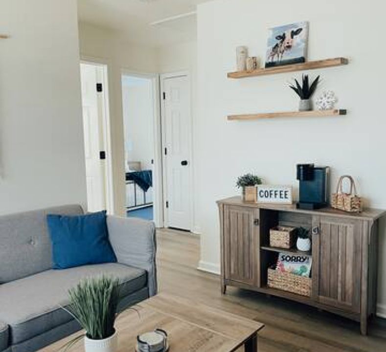 Living room looking toward coffee station and two bedrooms and bathroom.