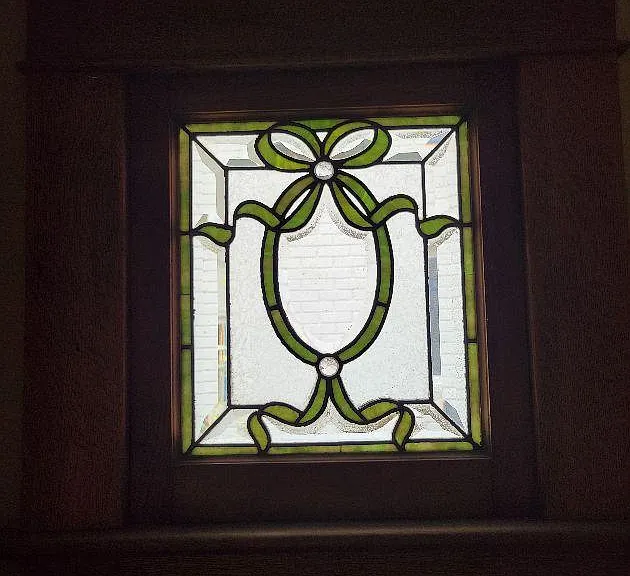 2 small stained glass windows bookend the living room fireplace