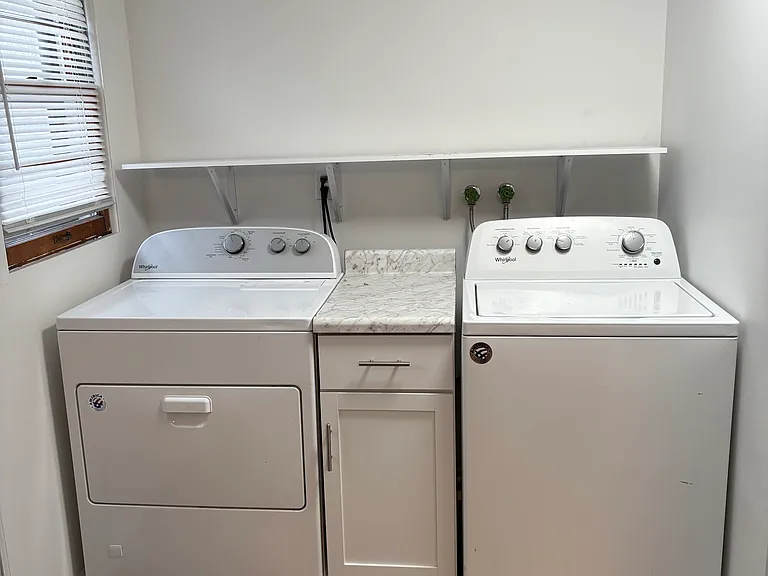main level Laundry room with shelving and cabinet
