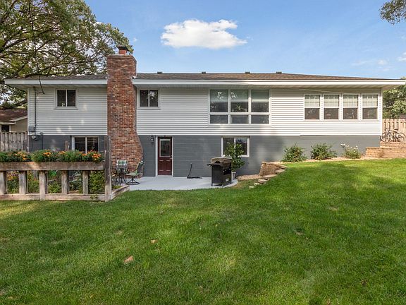 Back view of home with retaining walls, 2 patio/deck areas and garden.