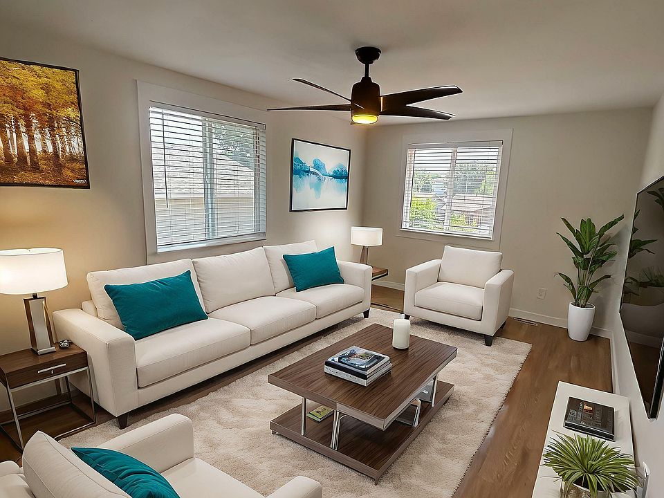 Elegant living room with modern white sofas, vibrant teal cushions, and stylish wooden decor, perfect for a cozy home ambiance.