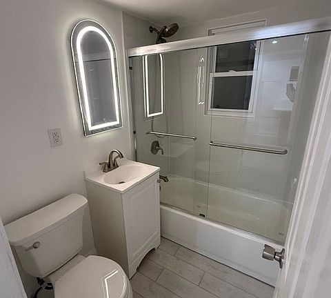 Renovated bathroom with LED mirror, tile & glass door