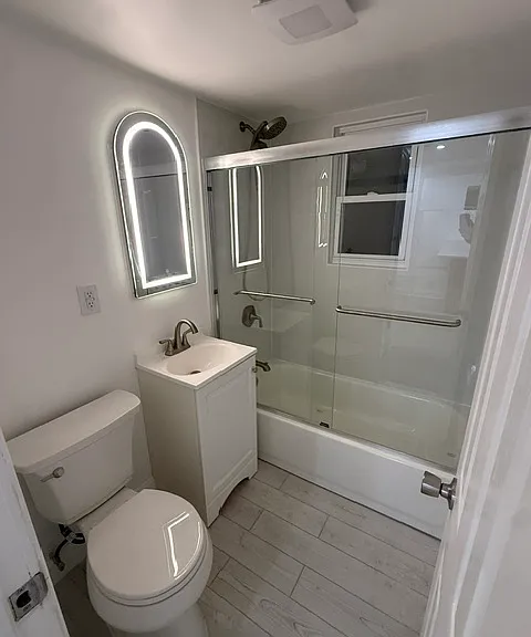 Renovated bathroom with LED mirror, tile & glass door