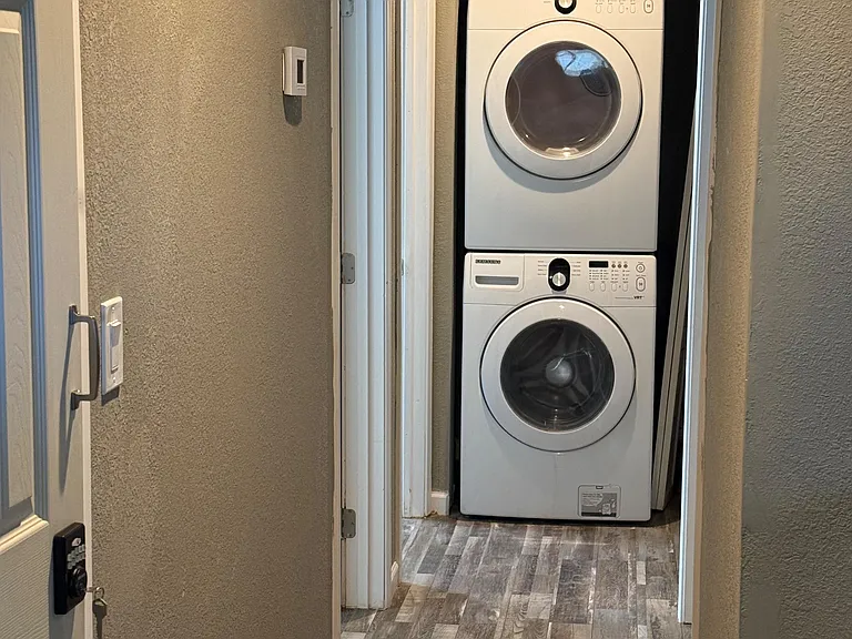 Dedicated laundry nook with stacked washer/dryer and durable flooring for convenient in-home wash days.