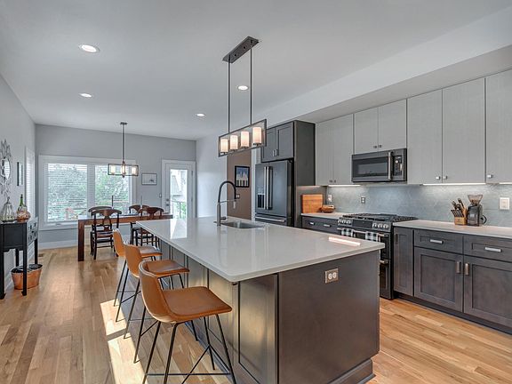 Modern GE Cafe appliances and gas range stove. Spacious kitchen island with built in storage.