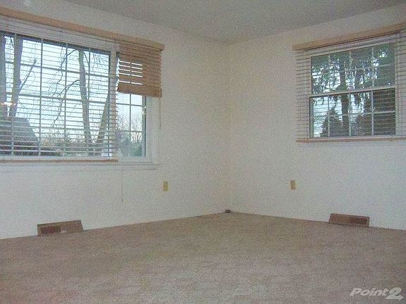 Living Room with hardwoods under carpeting, newer windows and blinds that stay.