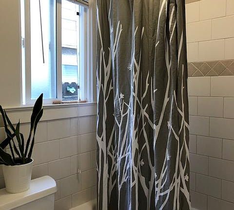 Note: picture of a similar unit Bathroom has tile floors, white tile bath/shower surround, window for natural light