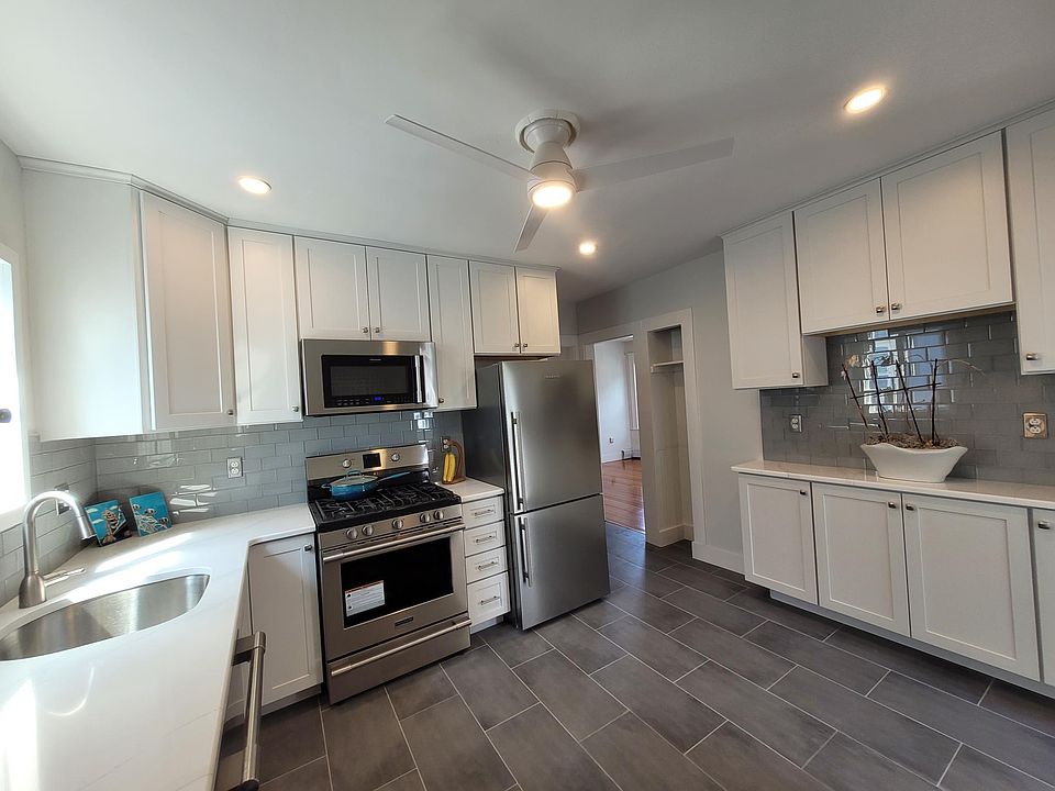 Kitchen. White ceiling height shaker cabinets, tiled floor, tiled backsplash, stone countertops, professional grade appliances.