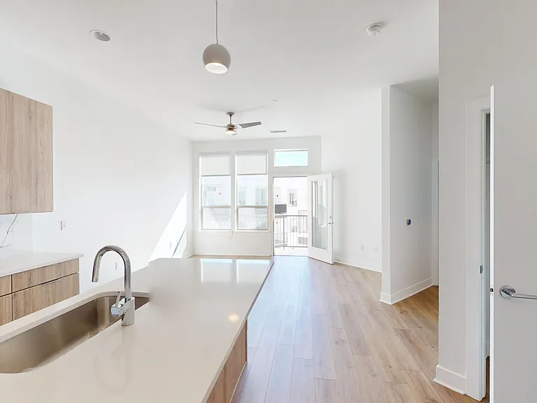 A view from the kitchen island showing the open-concept living area and large windows leading to a patio.