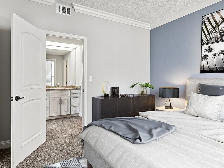 Carpeted bedroom with private bathroom.