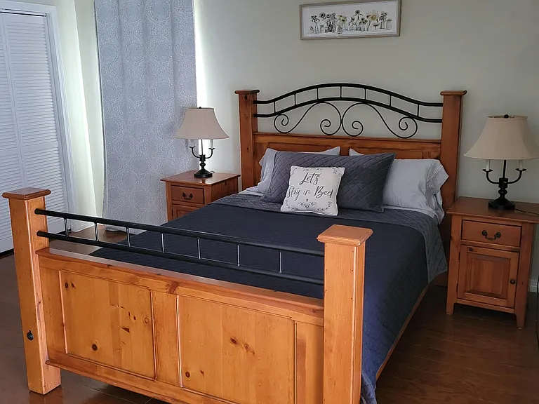 Master bedroom with queen size bed, night stands and lamps.