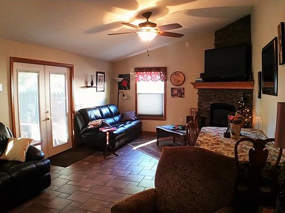 Great room with stacked stone gas fireplace, vaulted ceiling, tile floors