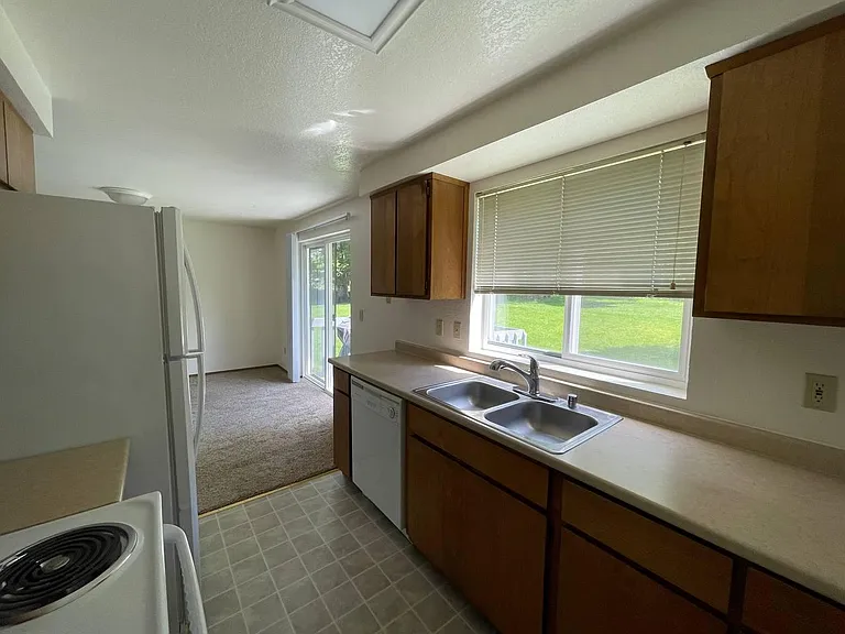 Kitchen with large window overlooking the backyard and open view into the living area