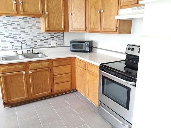 Kitchen with stainless steel appliances and newly tiled floor.