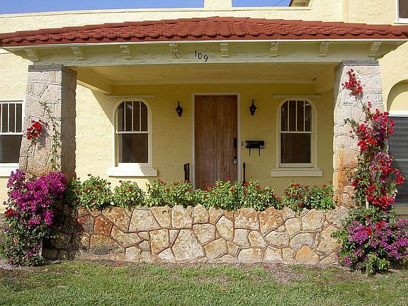 front entrance w/original coral flower bed and pecky cypress front door