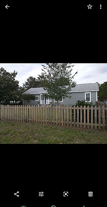 Beautiful front yard with crepe myrtles and large magnolia tree.