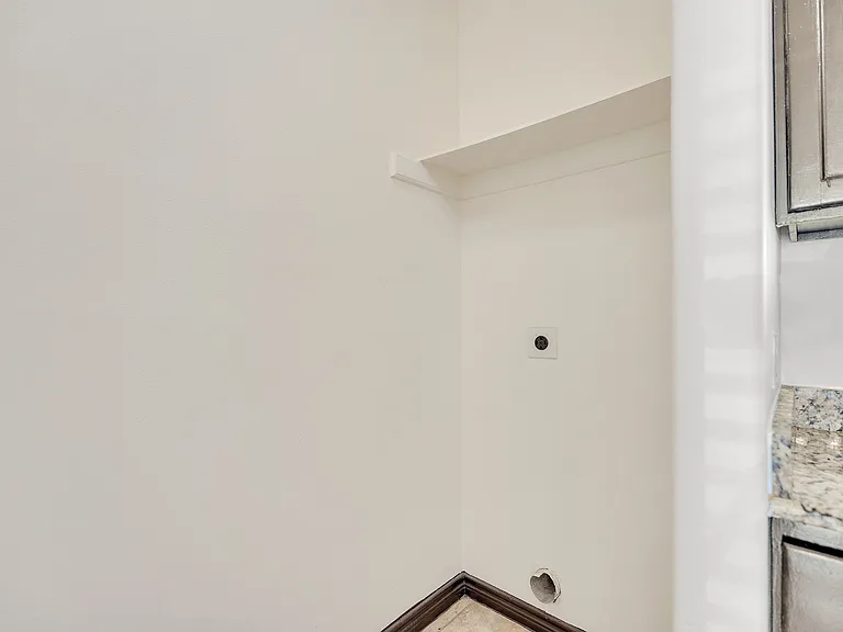 A white wall with a sink and cabinet, part of the interior design at La Joya Apartments in Laredo, Texas