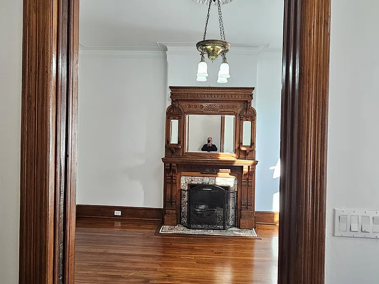 1st floor: entrance to living room with original sliding door and fireplace.