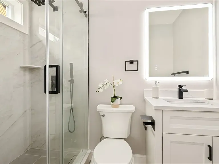 Modern luxury: A sparkling, brand-new standing shower featuring premium granite finishes and sleek glass doors.