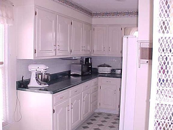 Charming Kitchen with White Cabinets, Appliances and Back Splash
