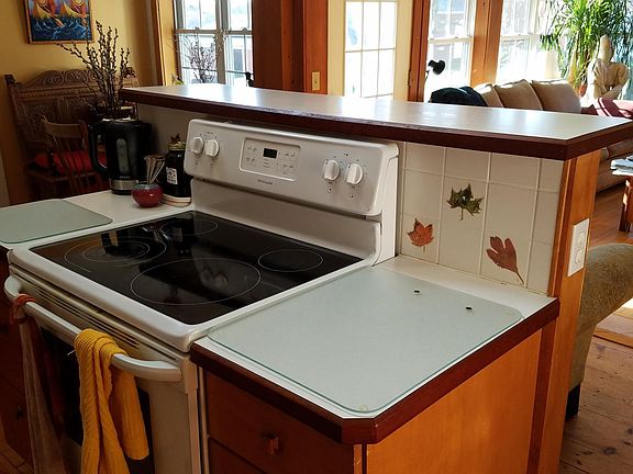 Solid surface electric range with views into windowed living room.