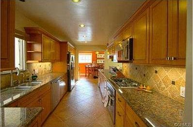 Remodeled kitchen with granite counter tops, tile backsplash, ti