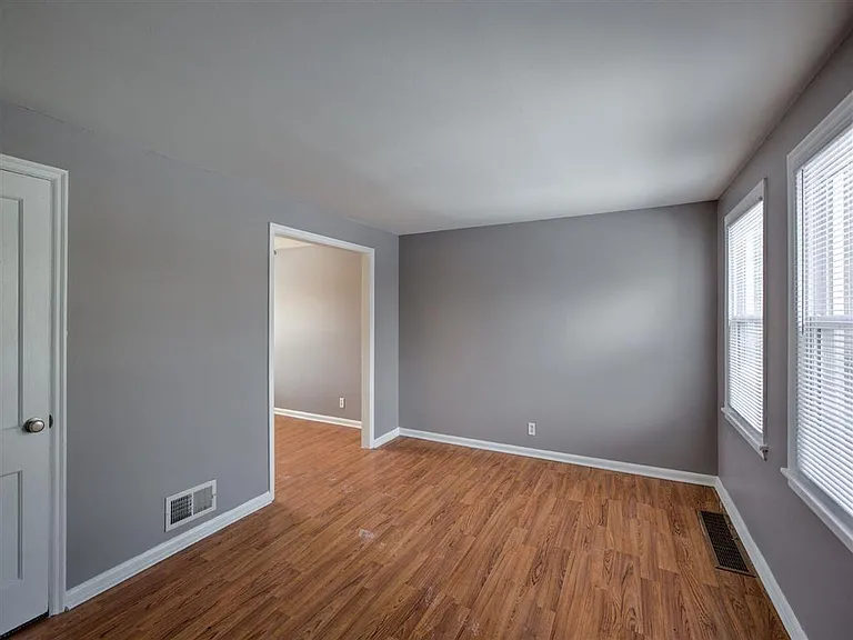 Living room with two large windows and stoage closet at Colonial Park.