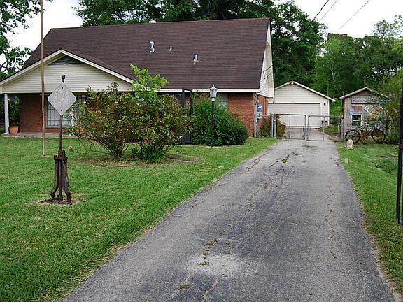 Black rod iron fence at front of home with electric gate.