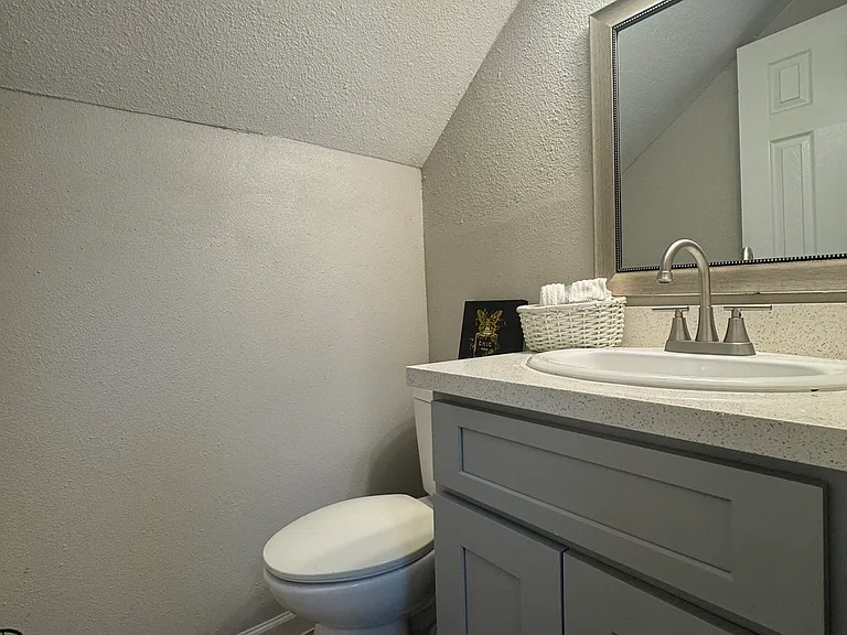 This stylish half bath features a modern vanity, updated fixtures, and a bright, efficient layout that makes the space feel fresh and inviting.