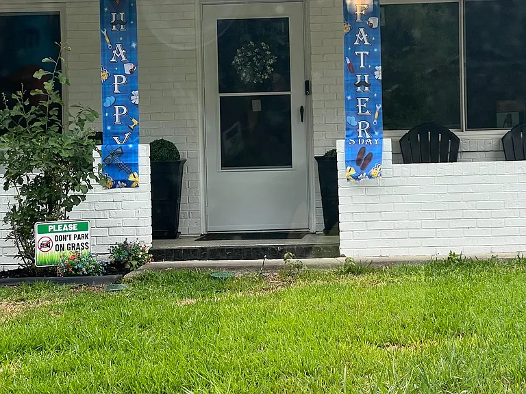Welcoming covered front entry with a screen door, large window, and neatly landscaped lawn for easy curb appeal.